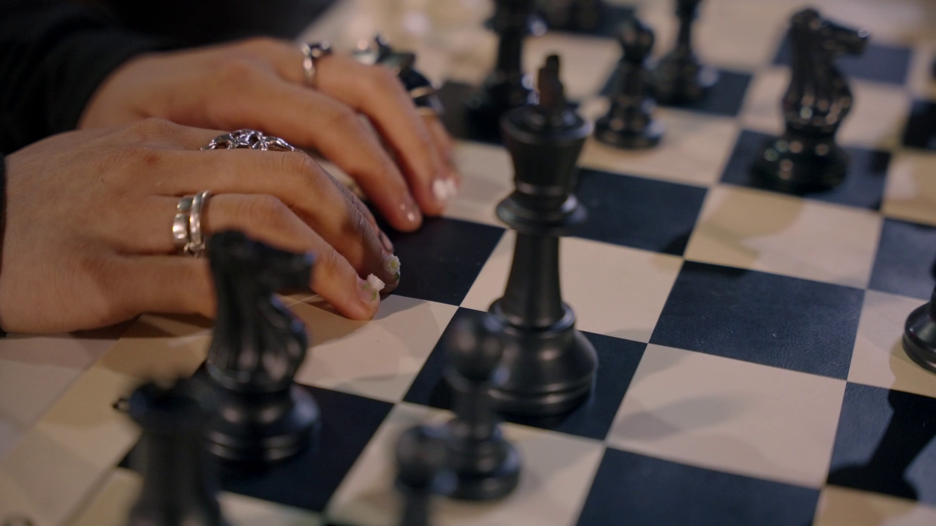 Close-up of hands moving chess pieces