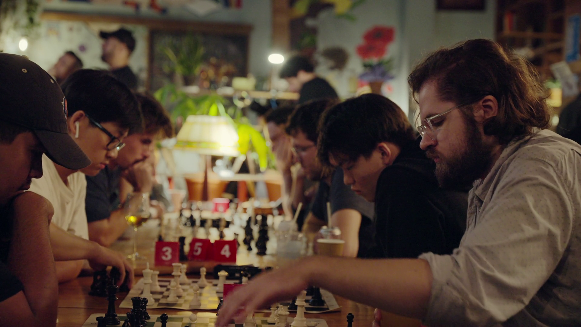 Players hunched over chessboards in a warmly lit Brooklyn bar
